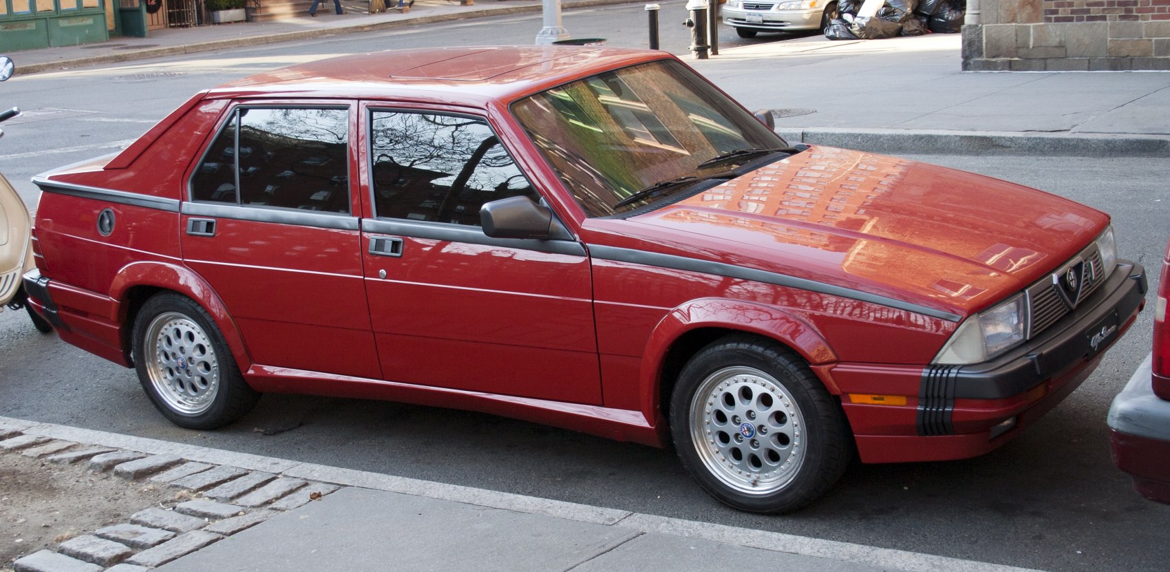 Angular four-door sedan with alloy wheels and prominent front black bumper