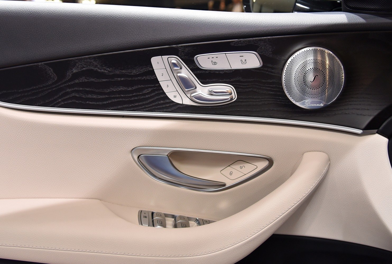 Door panel with seat adjustment controls and Burmester speaker