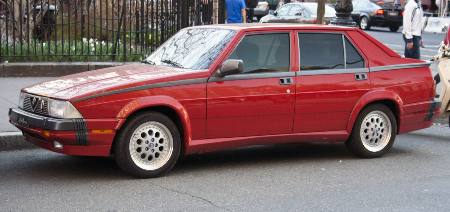 Red four-door sedan with angular design and distinctive wheel rims