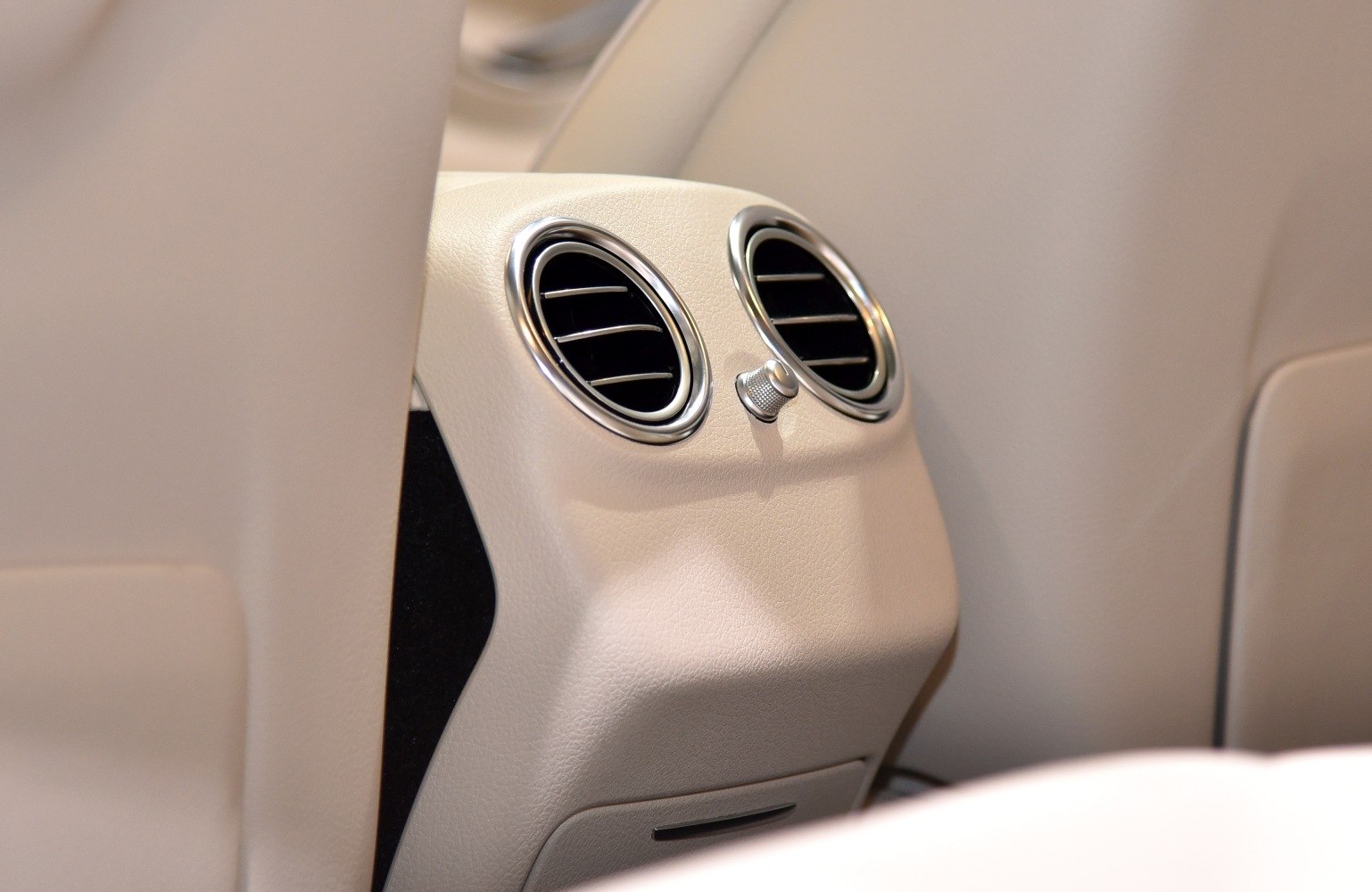 Rear HVAC air vents in beige car interior