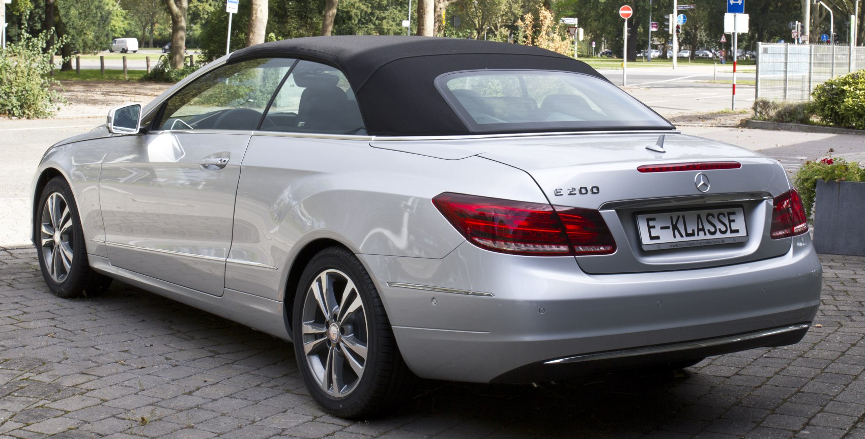 Rear view of silver convertible with soft top and alloy wheels