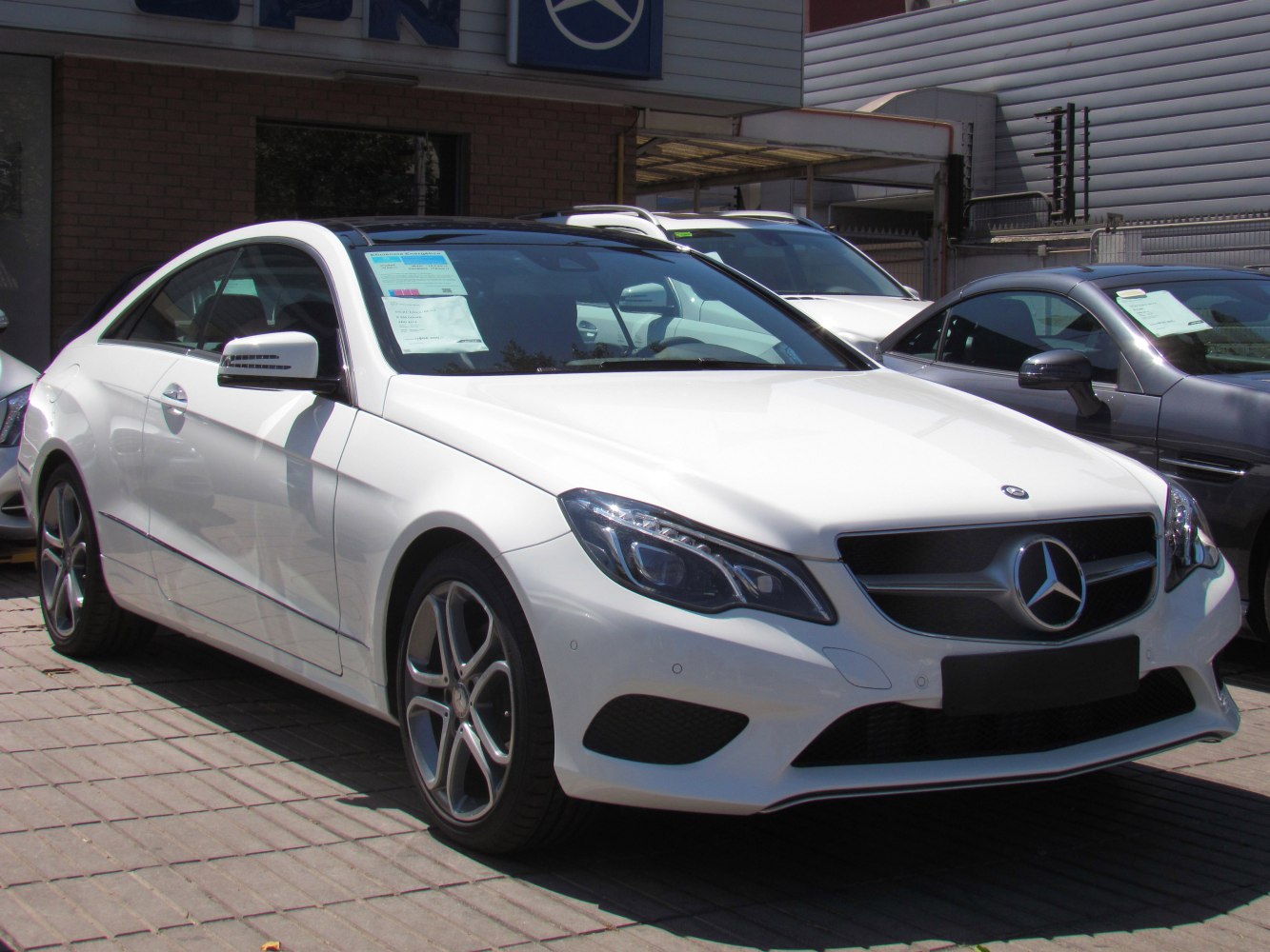 White luxury coupe front side with LED headlights and alloy wheels