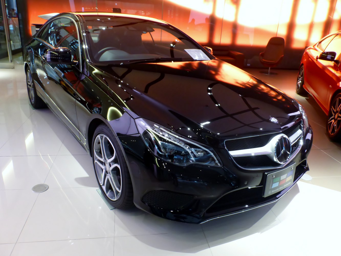 Black coupe front view with LED headlights and distinctive grille