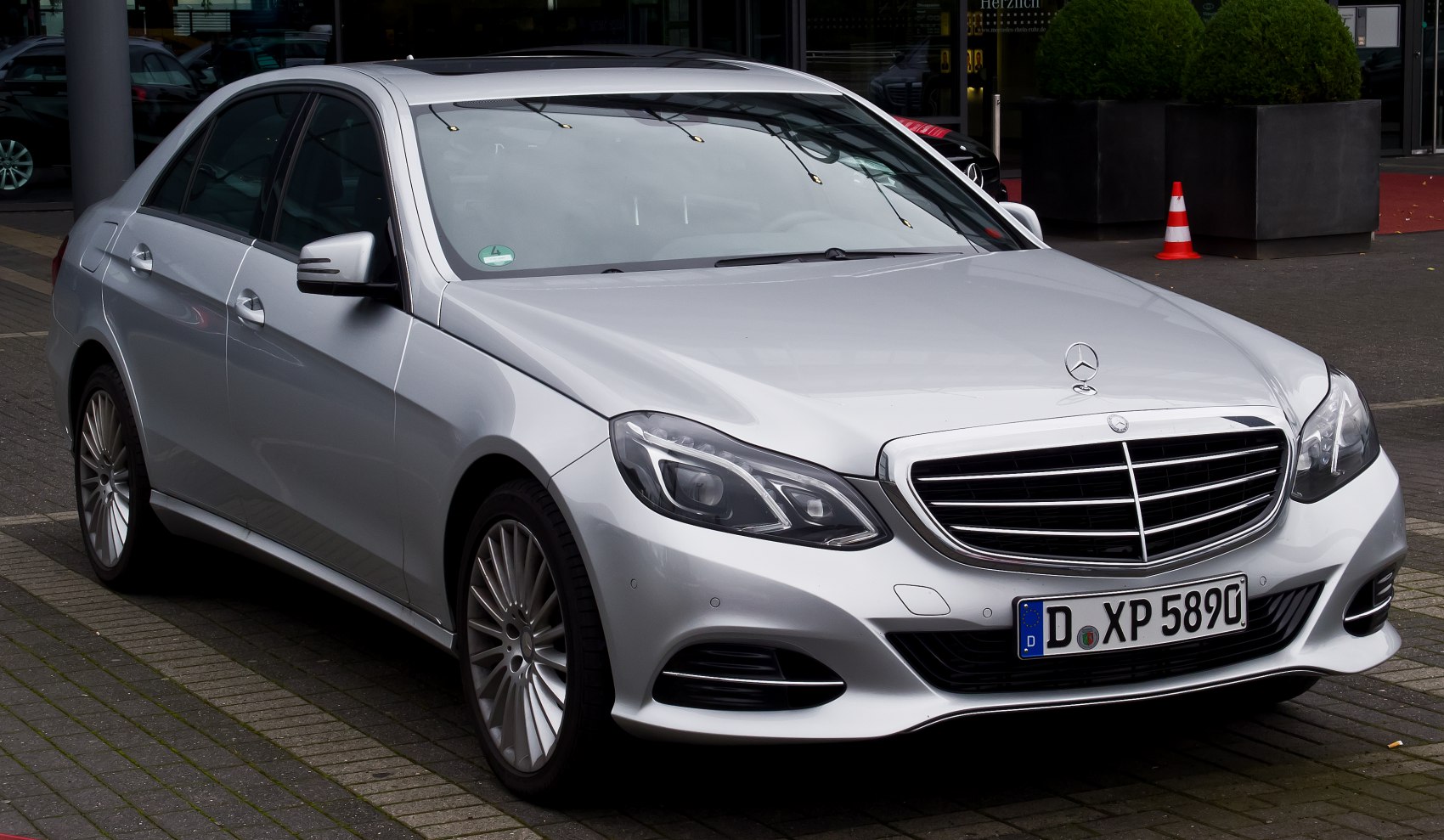 Front and side view of silver sedan with grille and alloy wheels