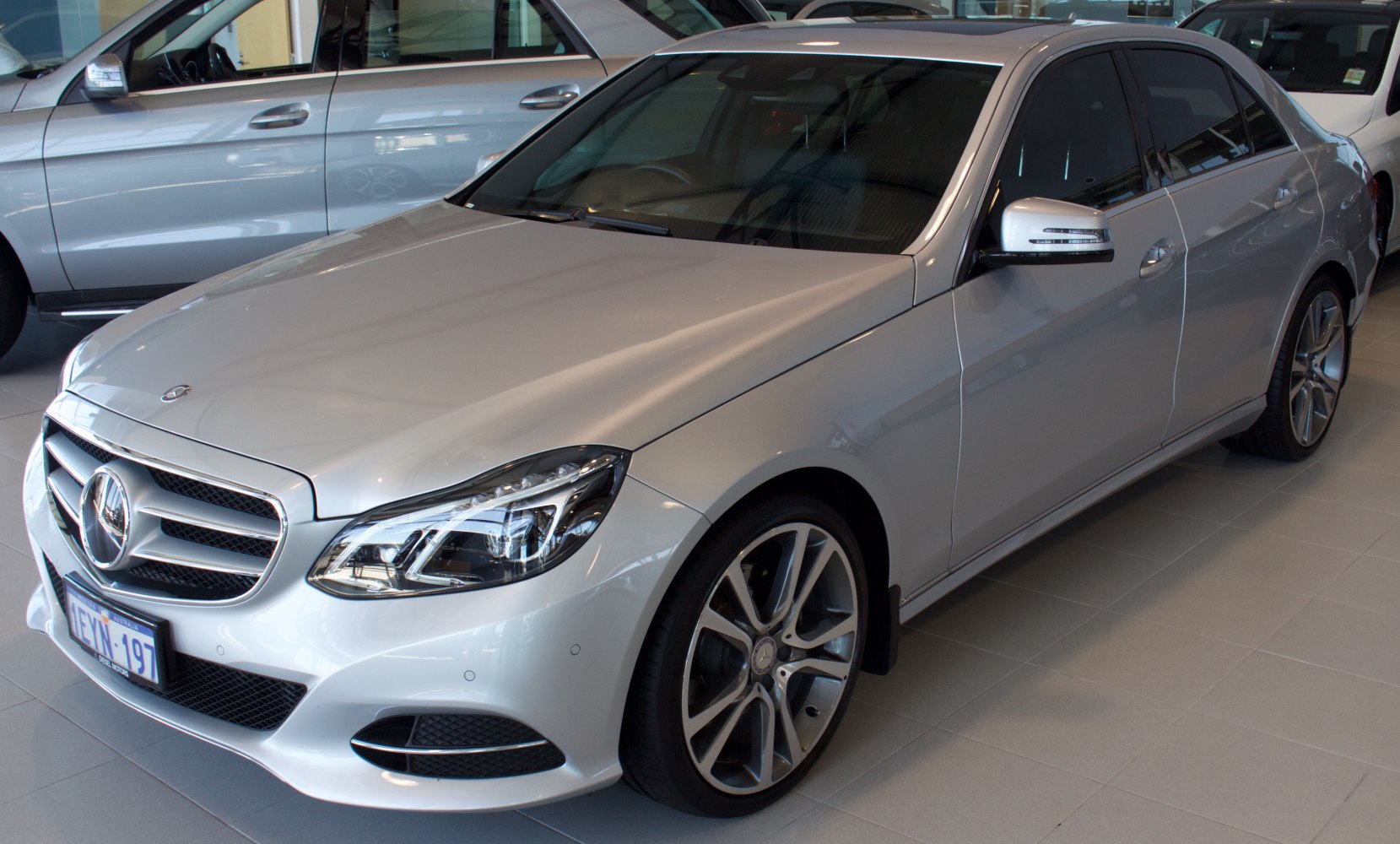 Silver luxury sedan front-side with distinctive headlights and grille