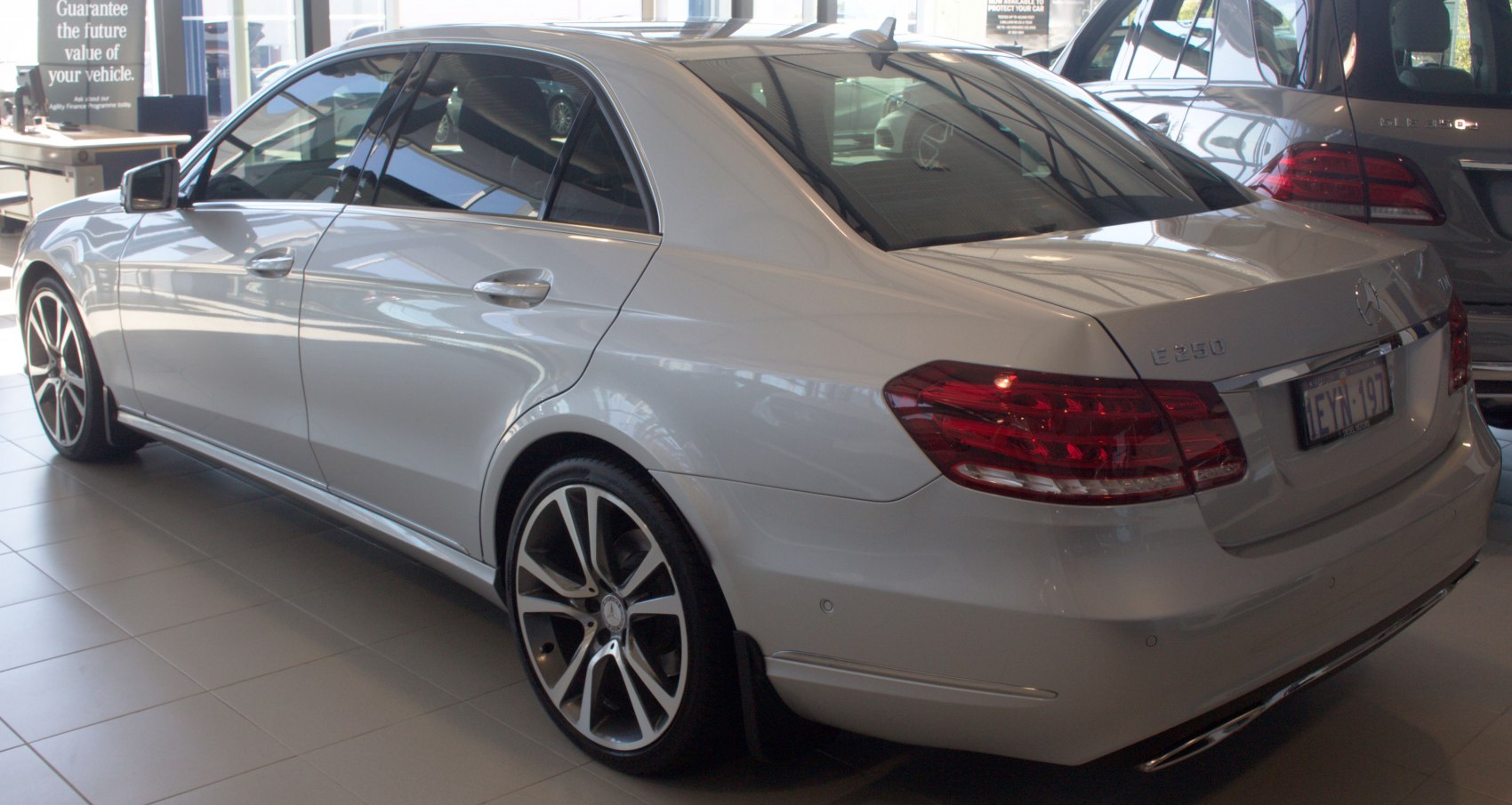 Silver luxury sedan rear side view with alloy wheels and LED taillights