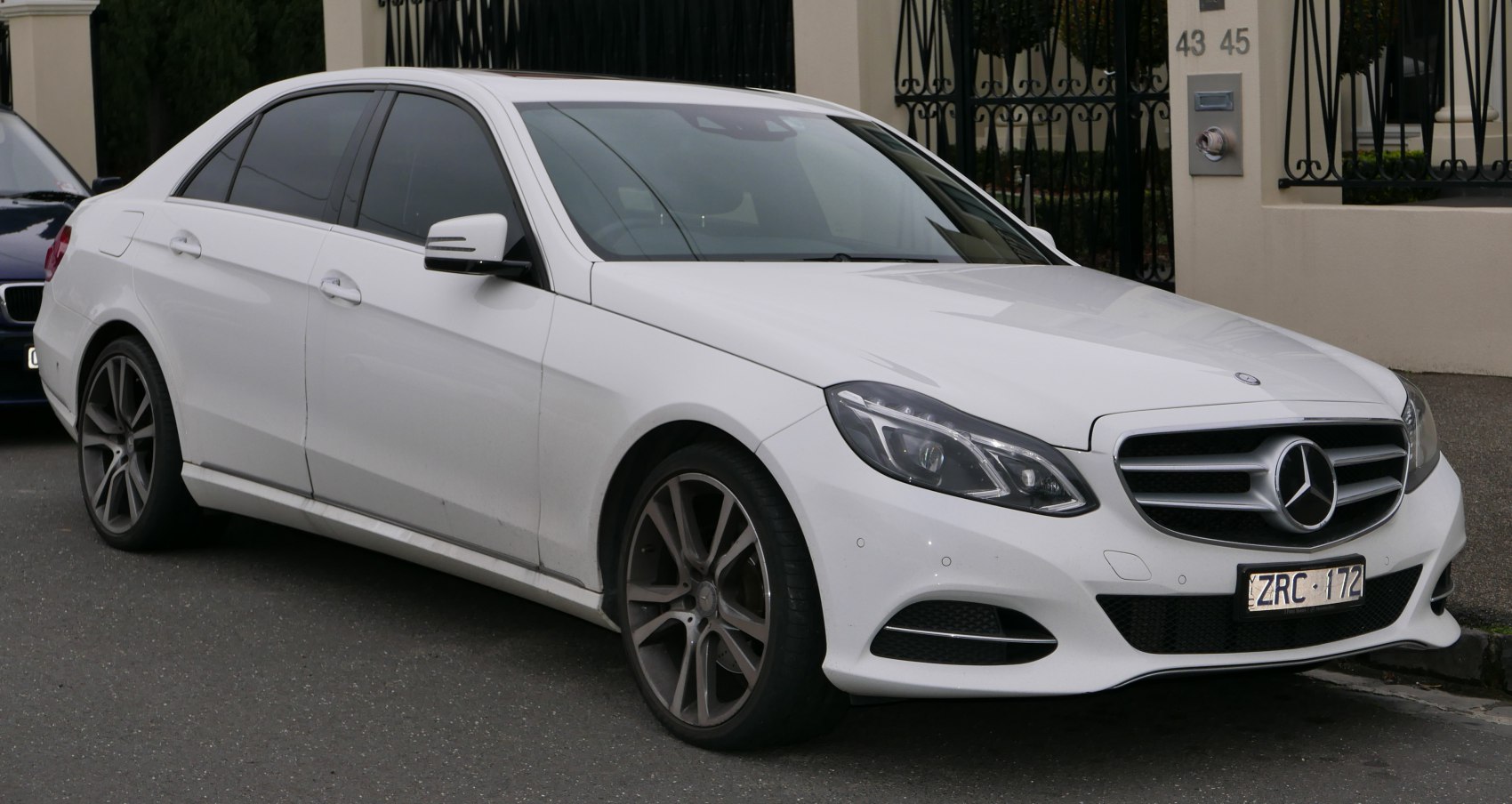 Front-side profile of white sedan with LED headlights and alloy wheels