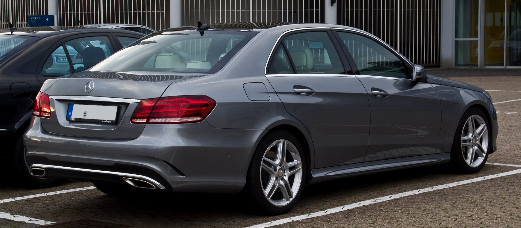 Rear and side profile of luxury sedan with dual exhaust and alloy wheels