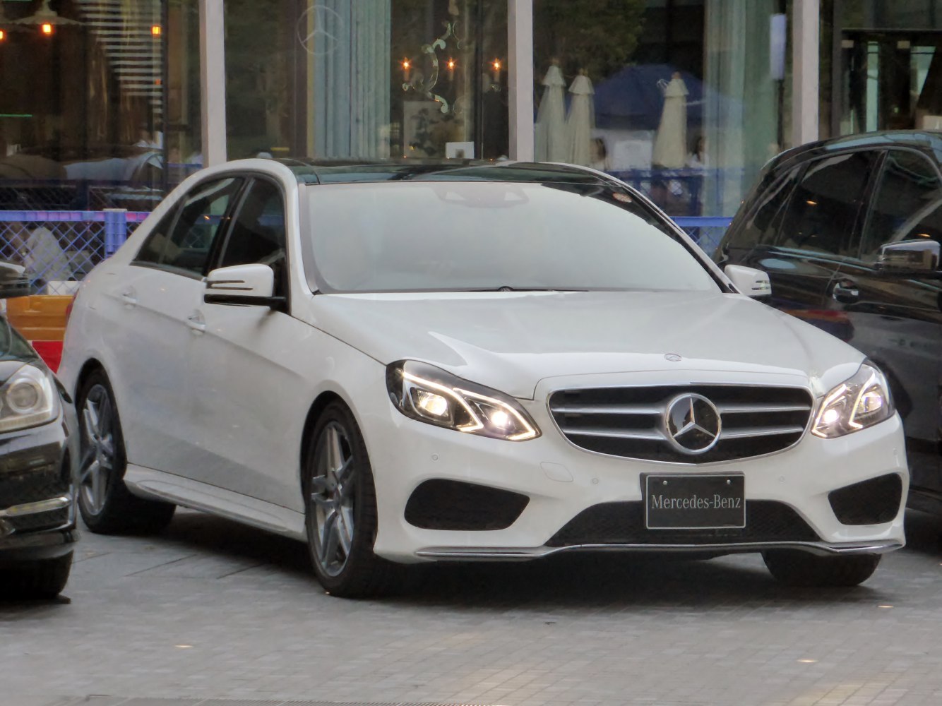 White sedan with LED headlights and chrome grille front view