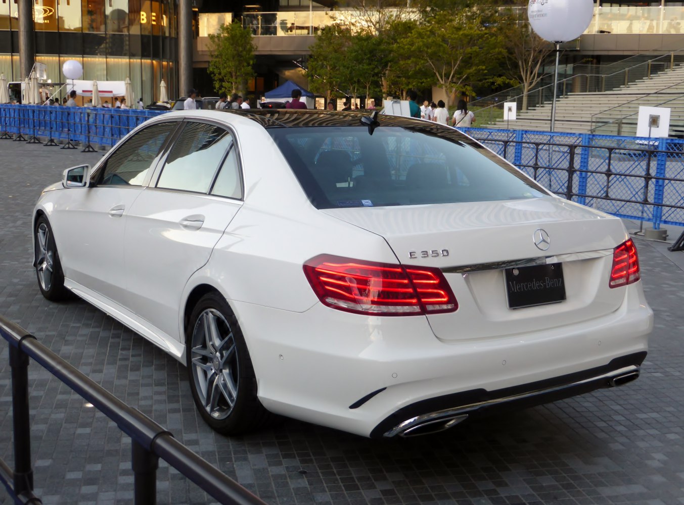 Rear view and taillights of a white luxury sedan with dual exhaust and alloy wheels