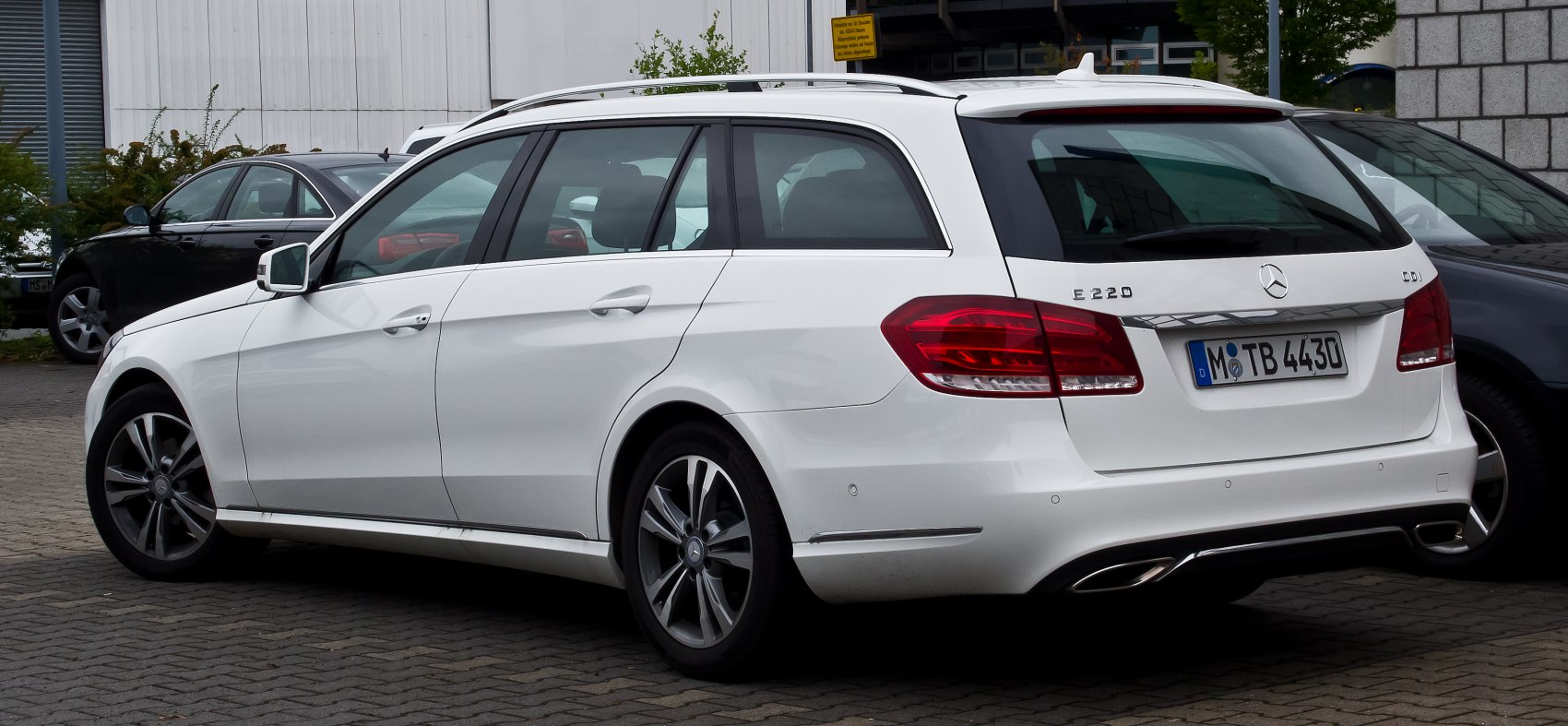 Rear and side view of white station wagon with alloy wheels