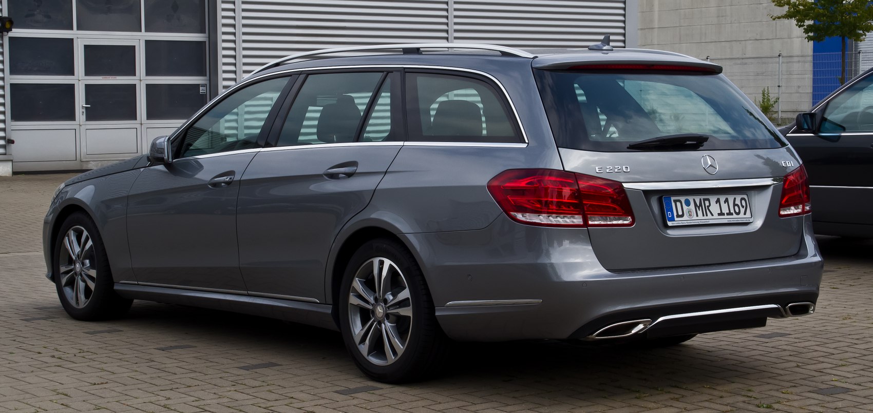 Rear and side view of a silver station wagon with distinct tail lights and dual exhausts