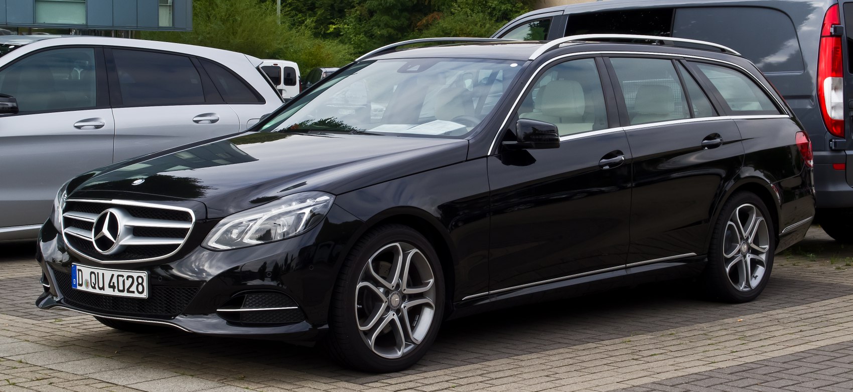 Black station wagon with sporty alloy wheels and chrome trim side profile.