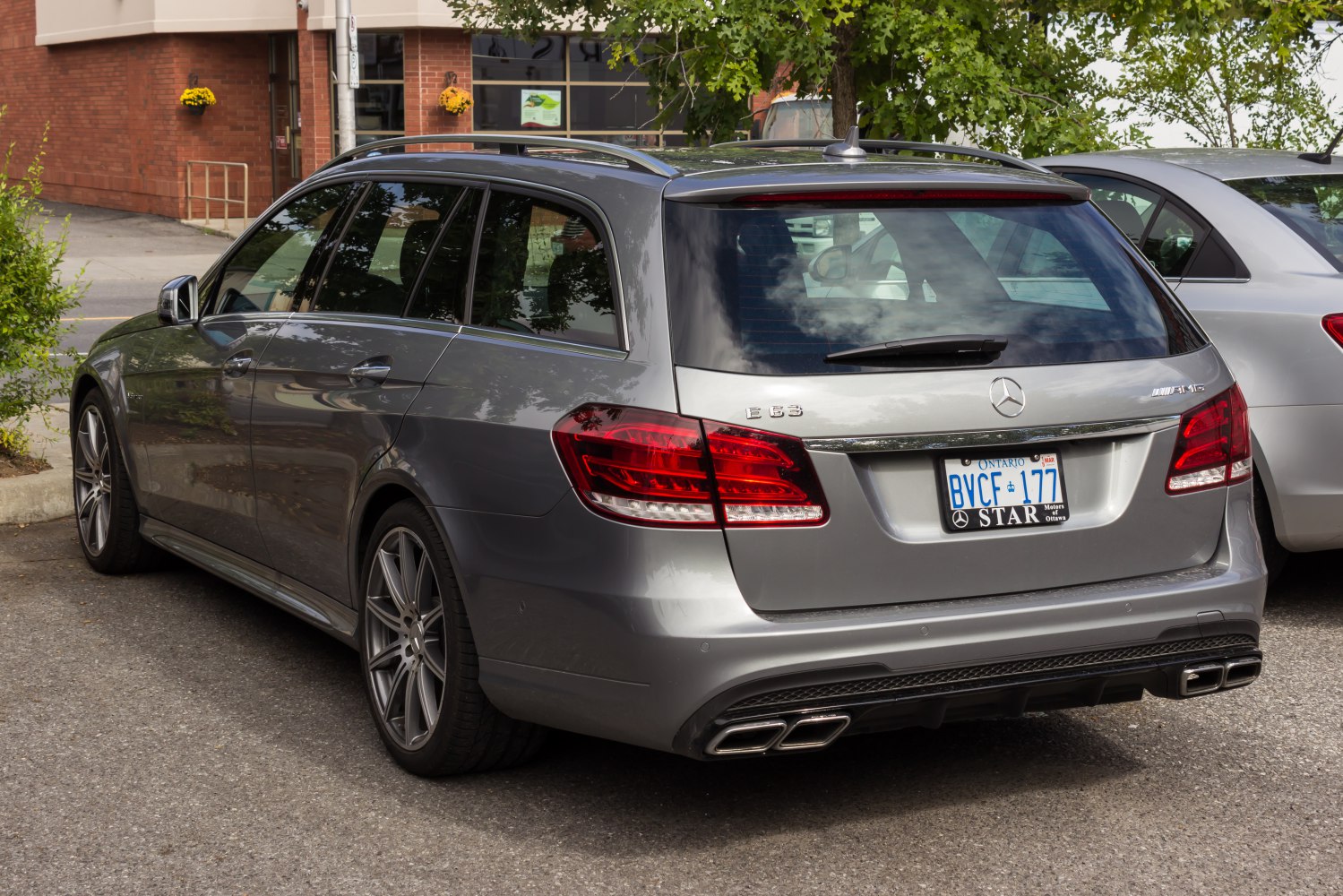 Rear view of silver station wagon with AMG exhaust and modern taillights