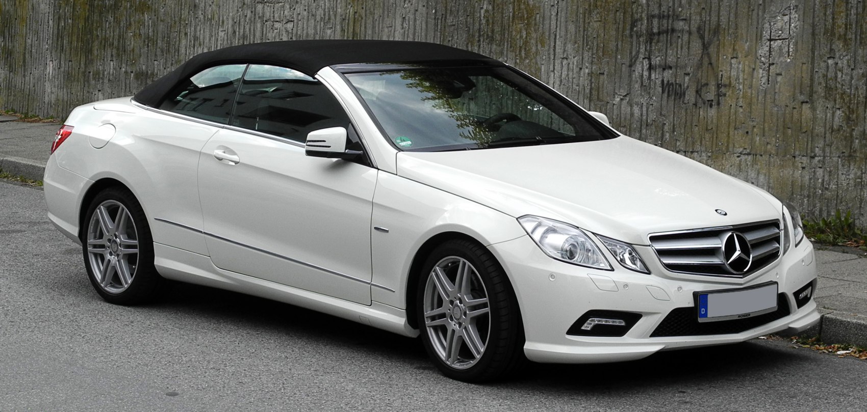 Front-side view of white soft top convertible with alloy wheels