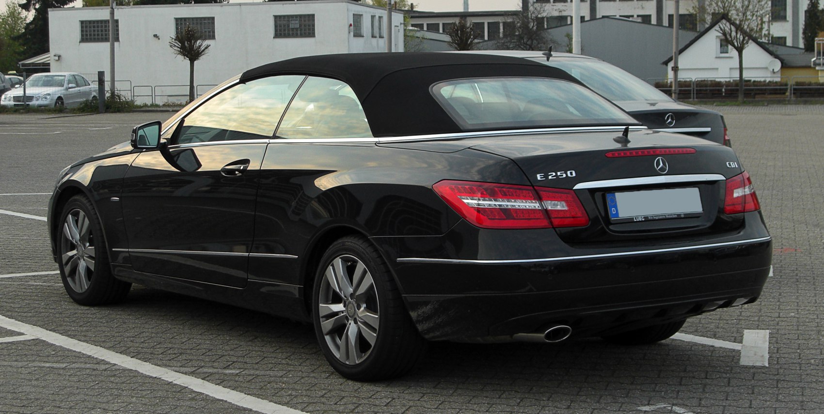 Black luxury convertible with soft fabric roof, rear and side profile