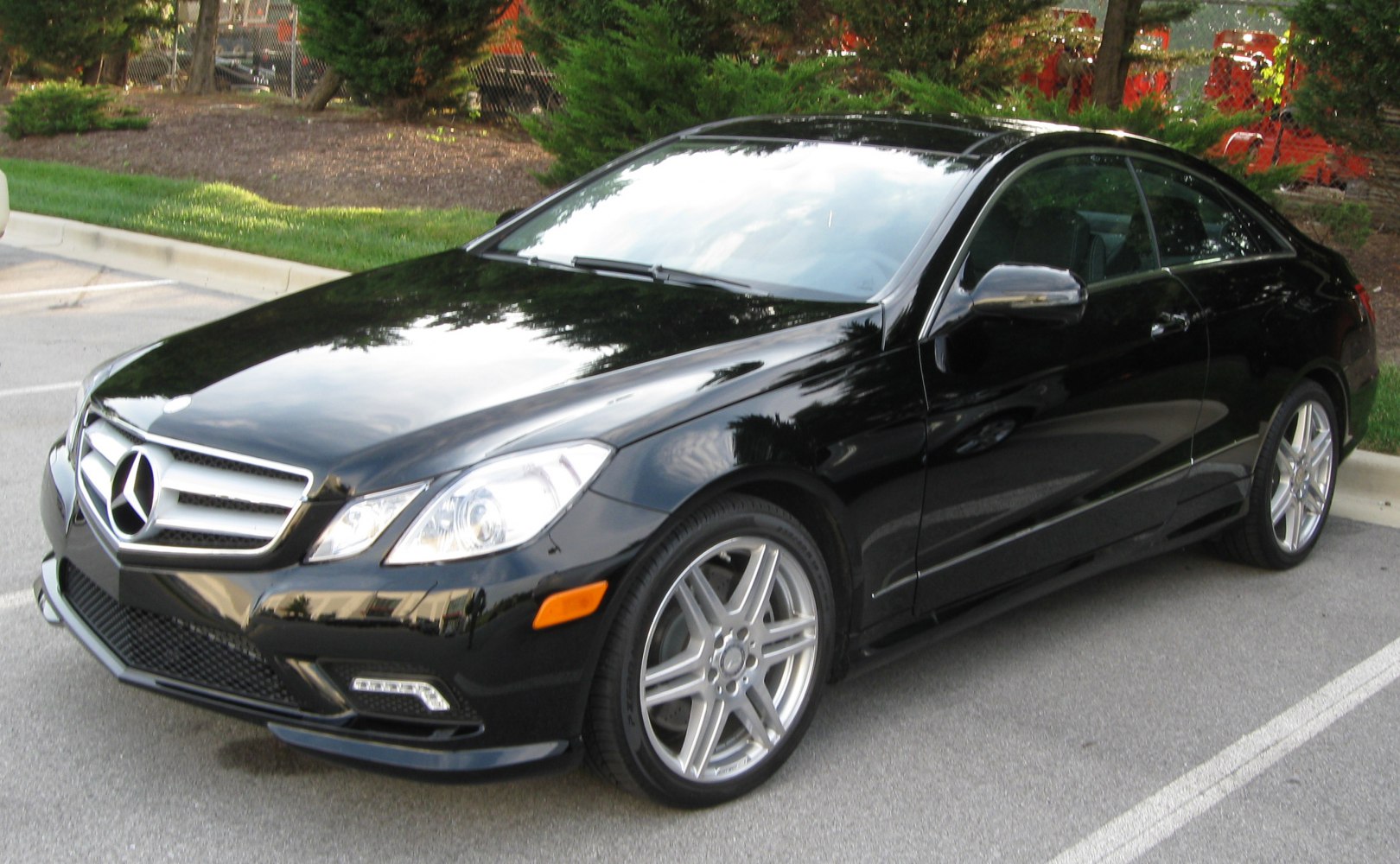 Front three-quarter view of a black luxury coupe with alloy wheels