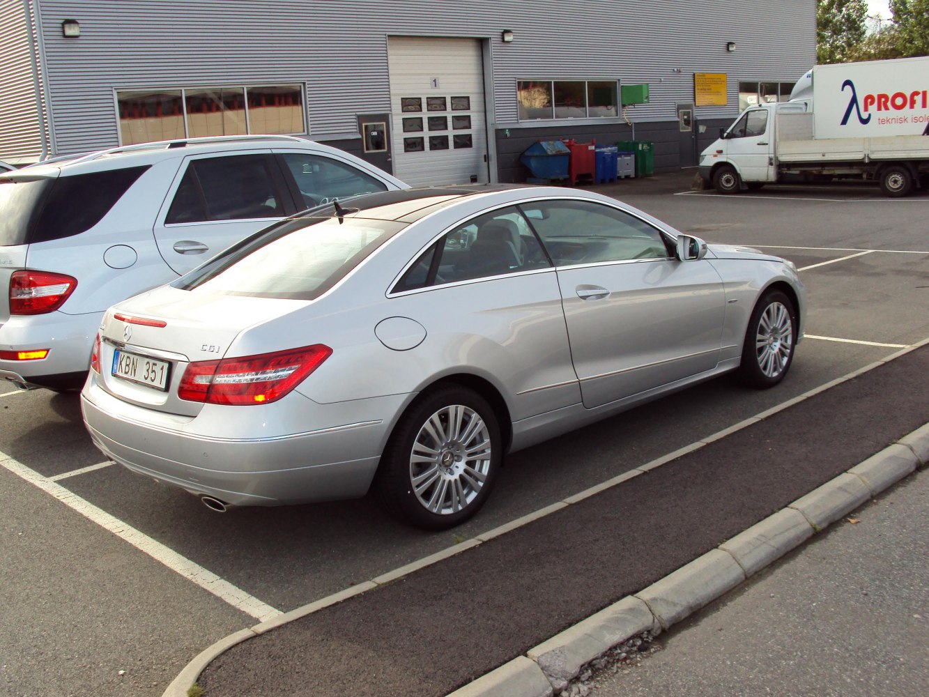 Silver luxury coupe with sleek rear side view and alloy wheels