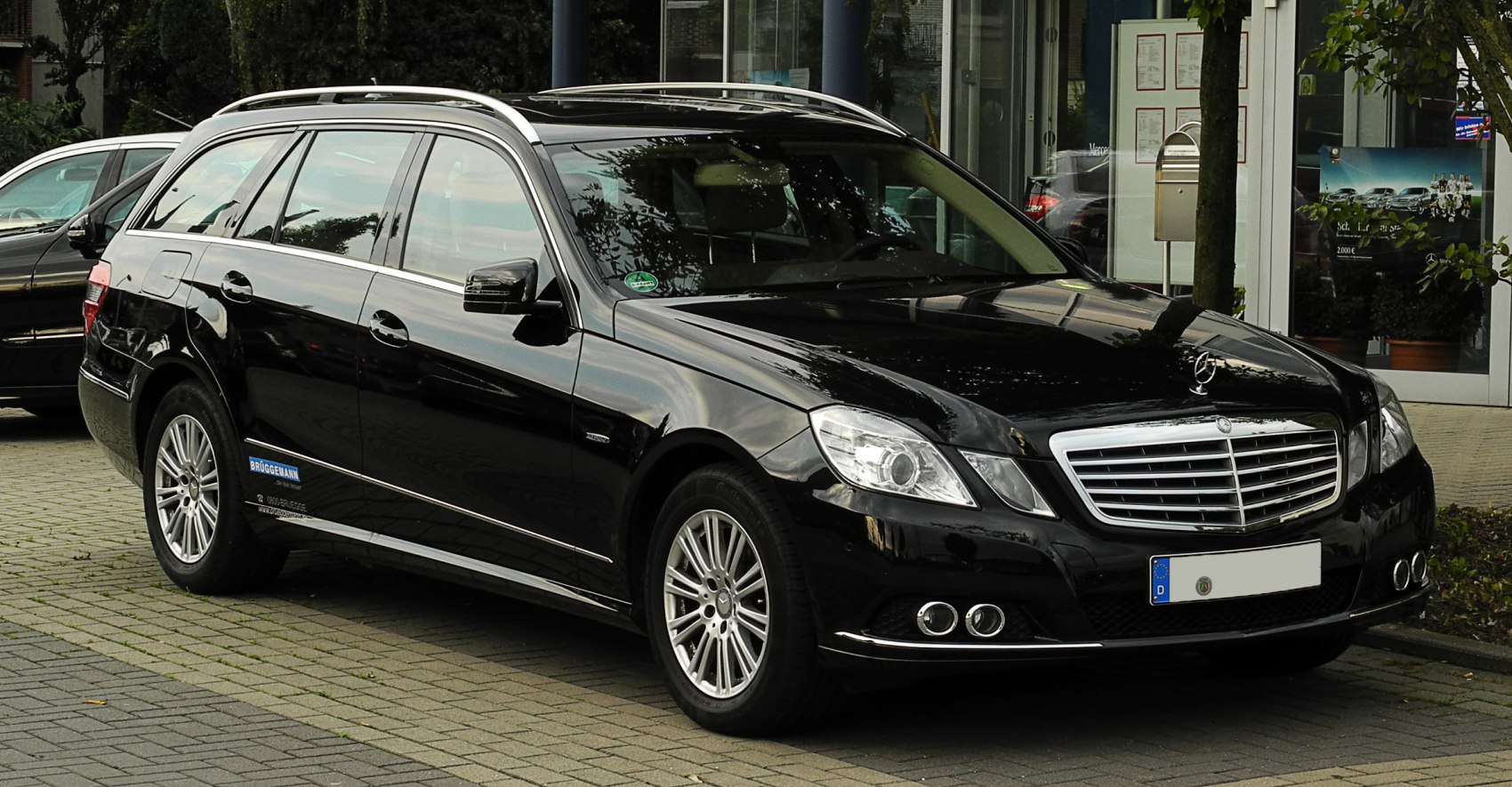 Black luxury station wagon with chrome grille and dual exhaust pipes