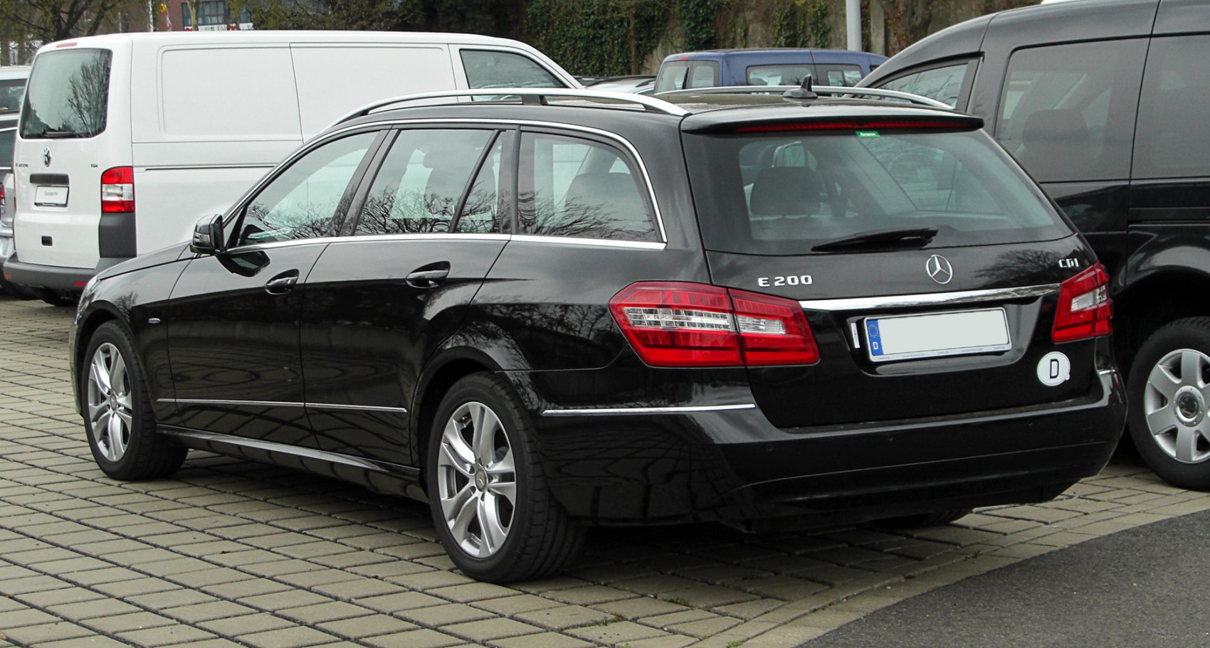 Sleek tail lights and roof rails on a black station wagon rear side.