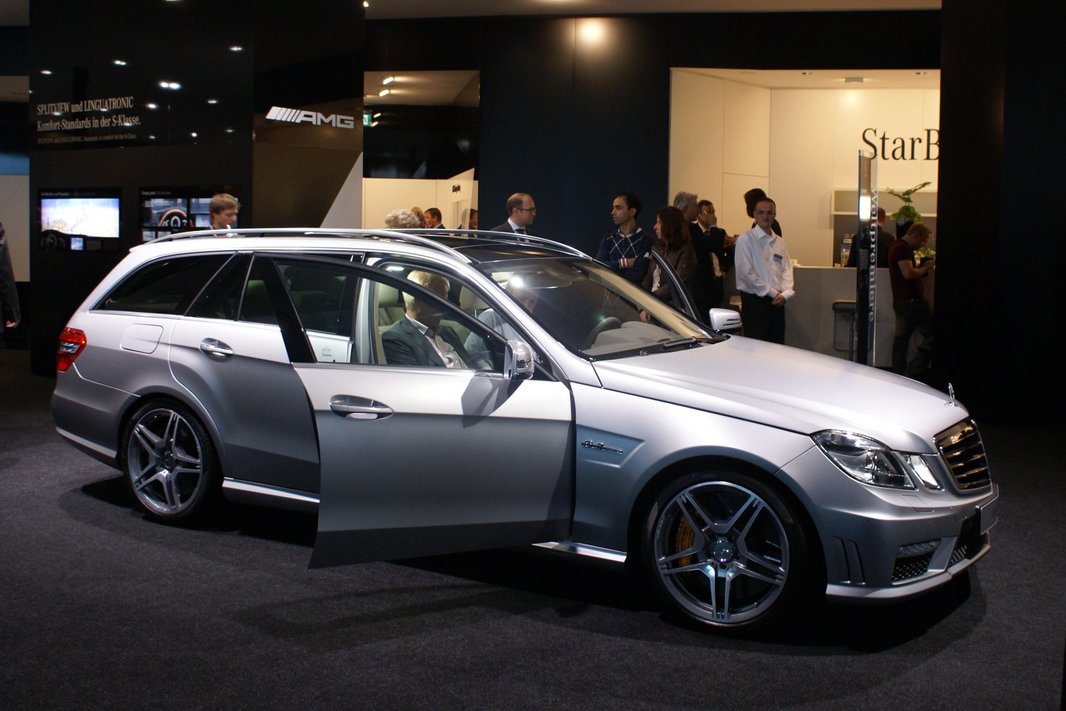 Silver station wagon with AMG wheels and open driver door