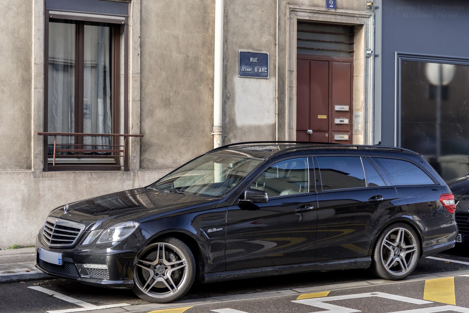 Black station wagon with AMG wheels parked on street