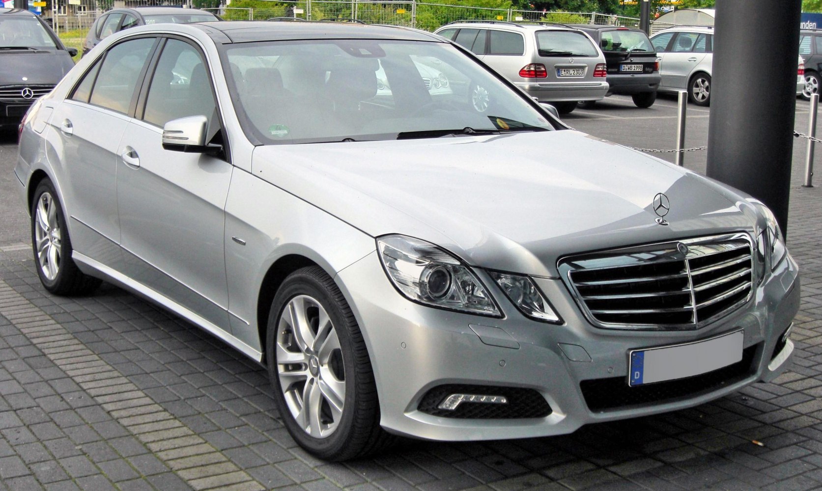 Silver luxury sedan front and side view with LED daytime running lights and alloy wheels