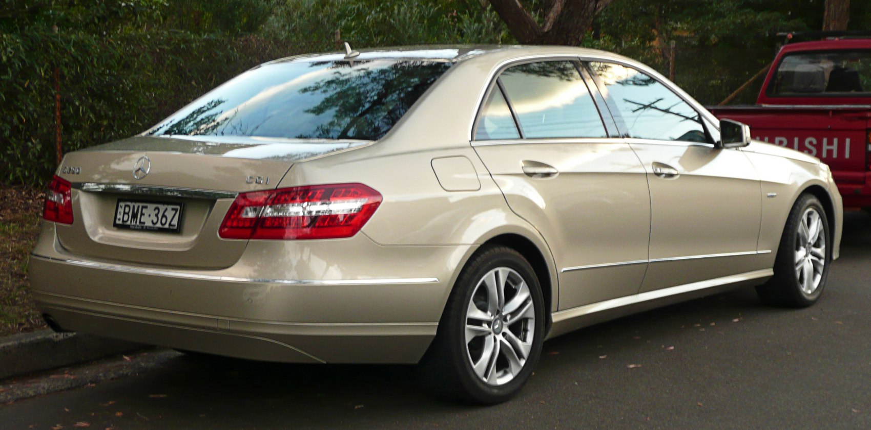Rear side view of luxury sedan featuring taillights and alloy wheels