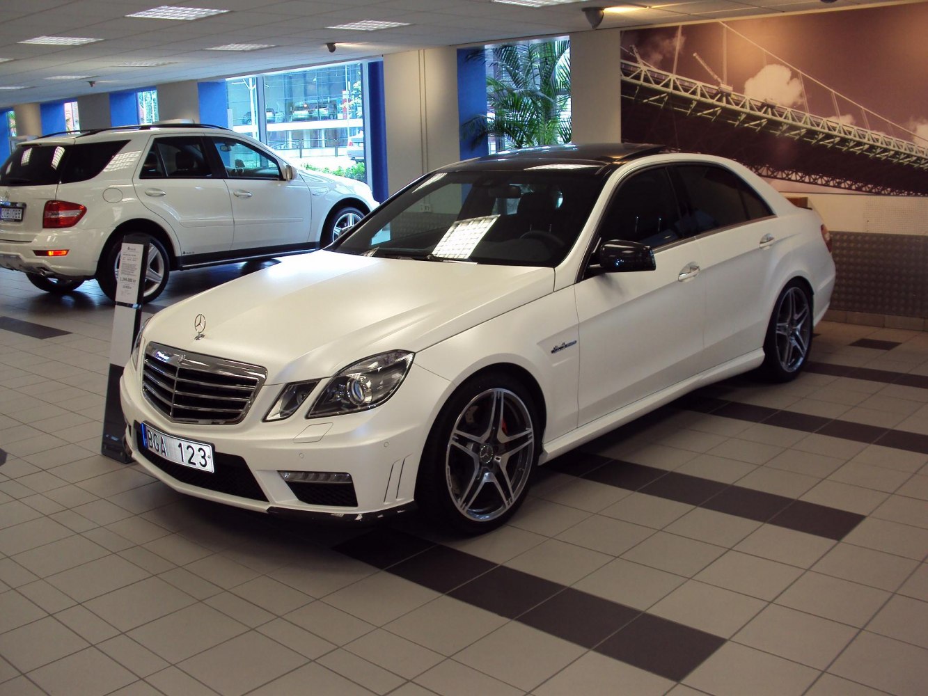 Front-side view of white sedan with AMG styling and sport rims in showroom