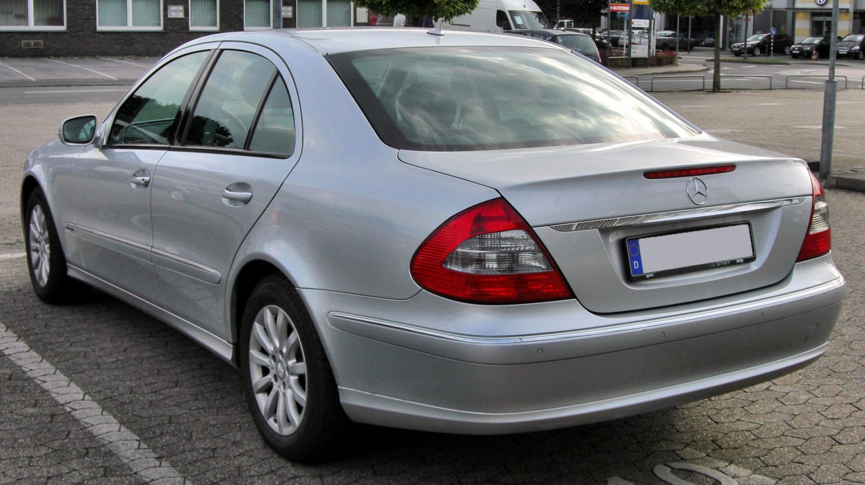 Silver sedan rear view with distinctive taillights and chrome trim