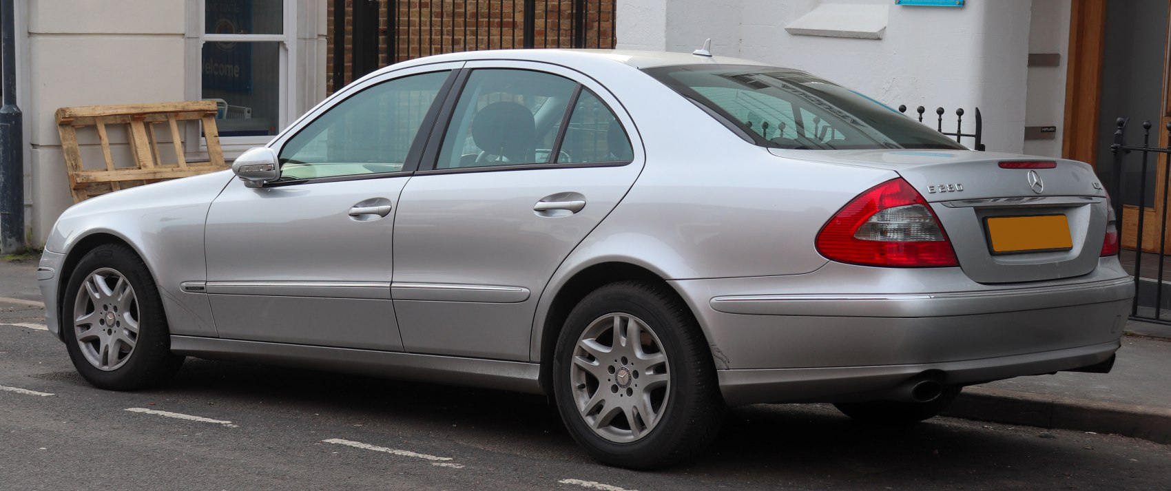 Silver sedan rear side view with alloy wheels and classic design