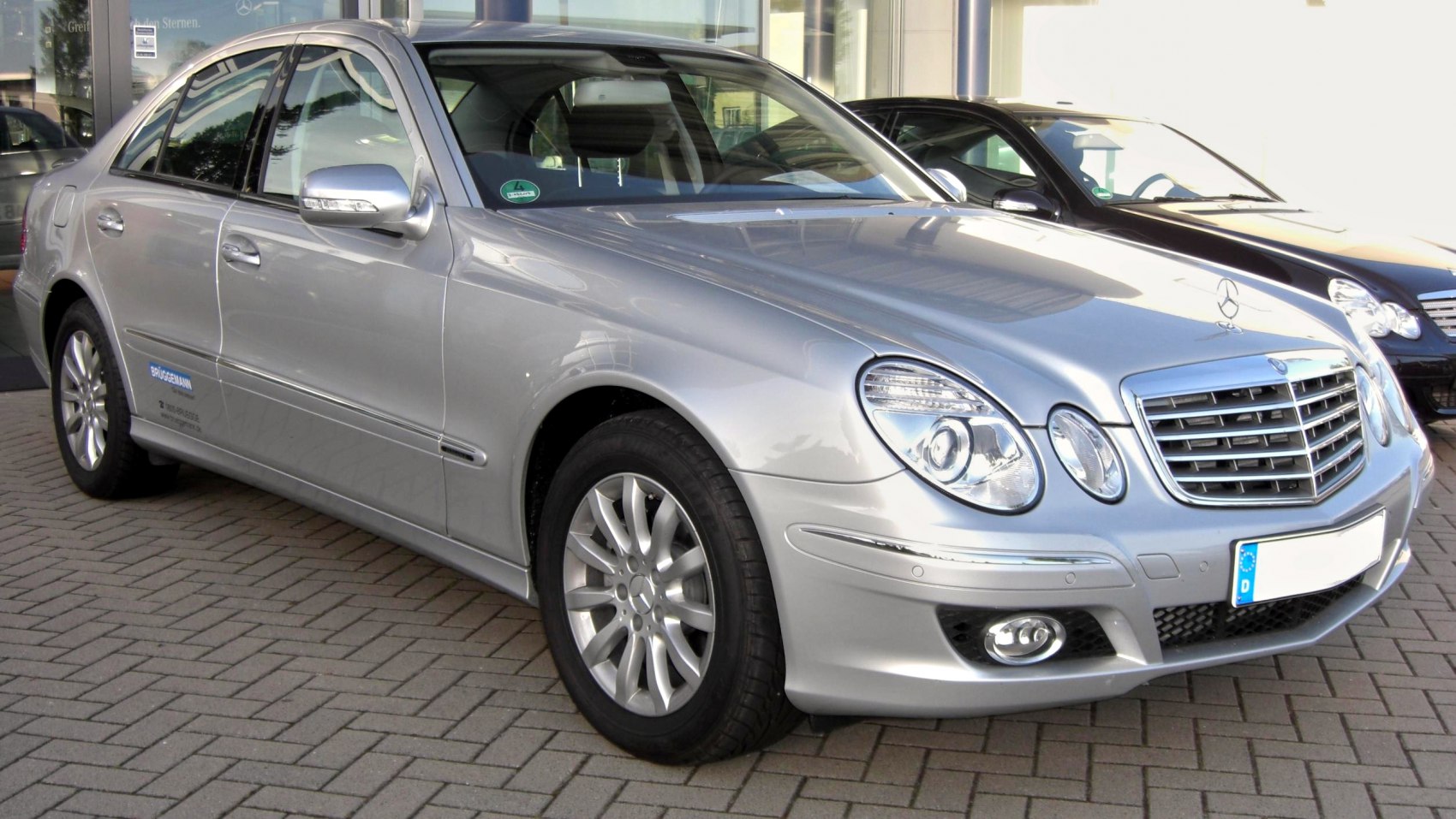 Silver sedan with distinctive dual headlights and prominent grille.