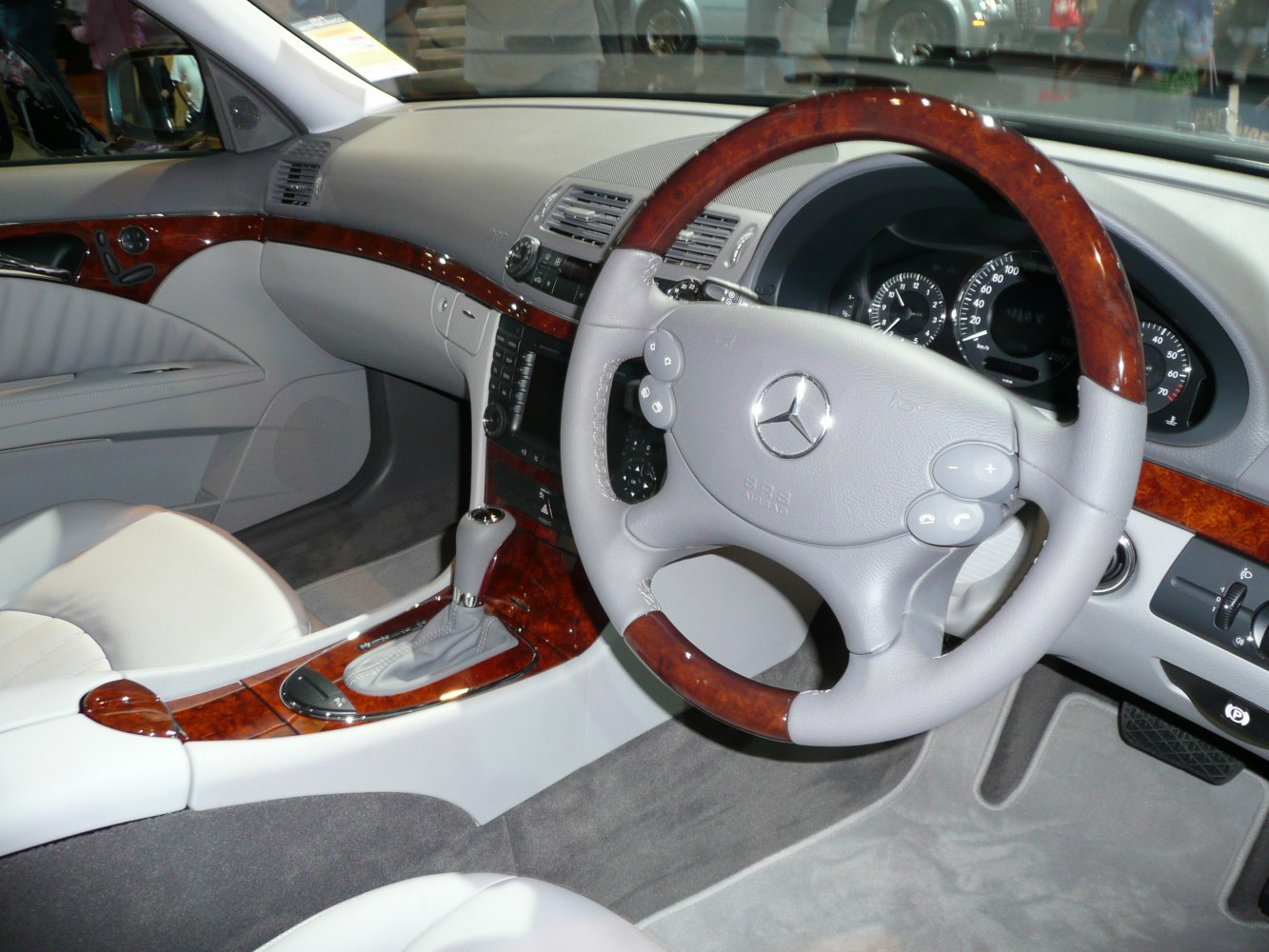 Wood-trimmed steering wheel and dashboard with gear shift and controls