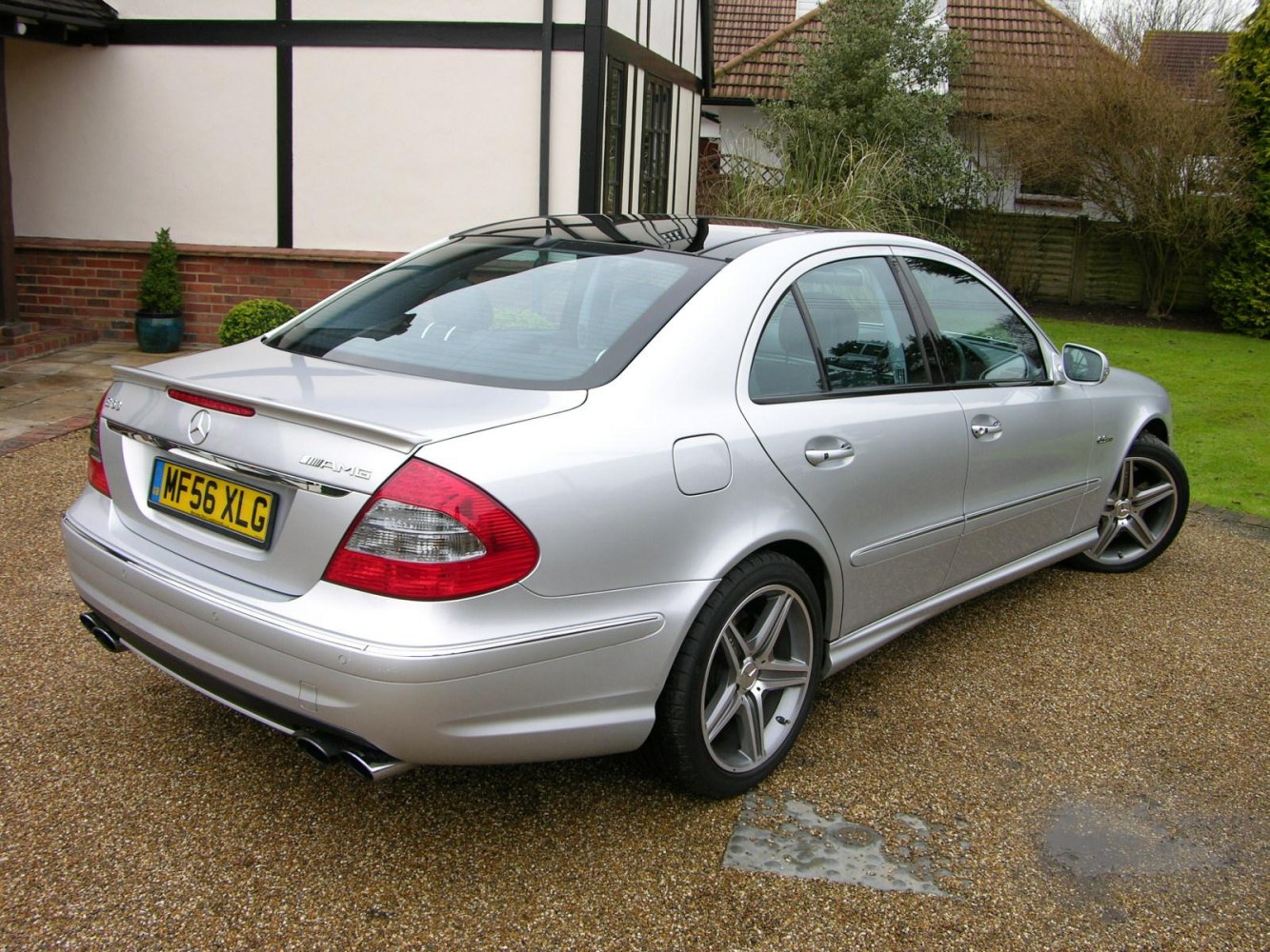 Rear side view of silver sedan, AMG badge, rear spoiler