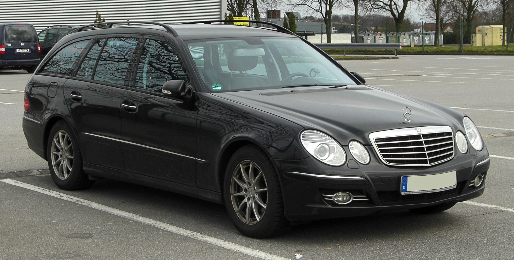 Black estate car with dual round headlights and roof rails