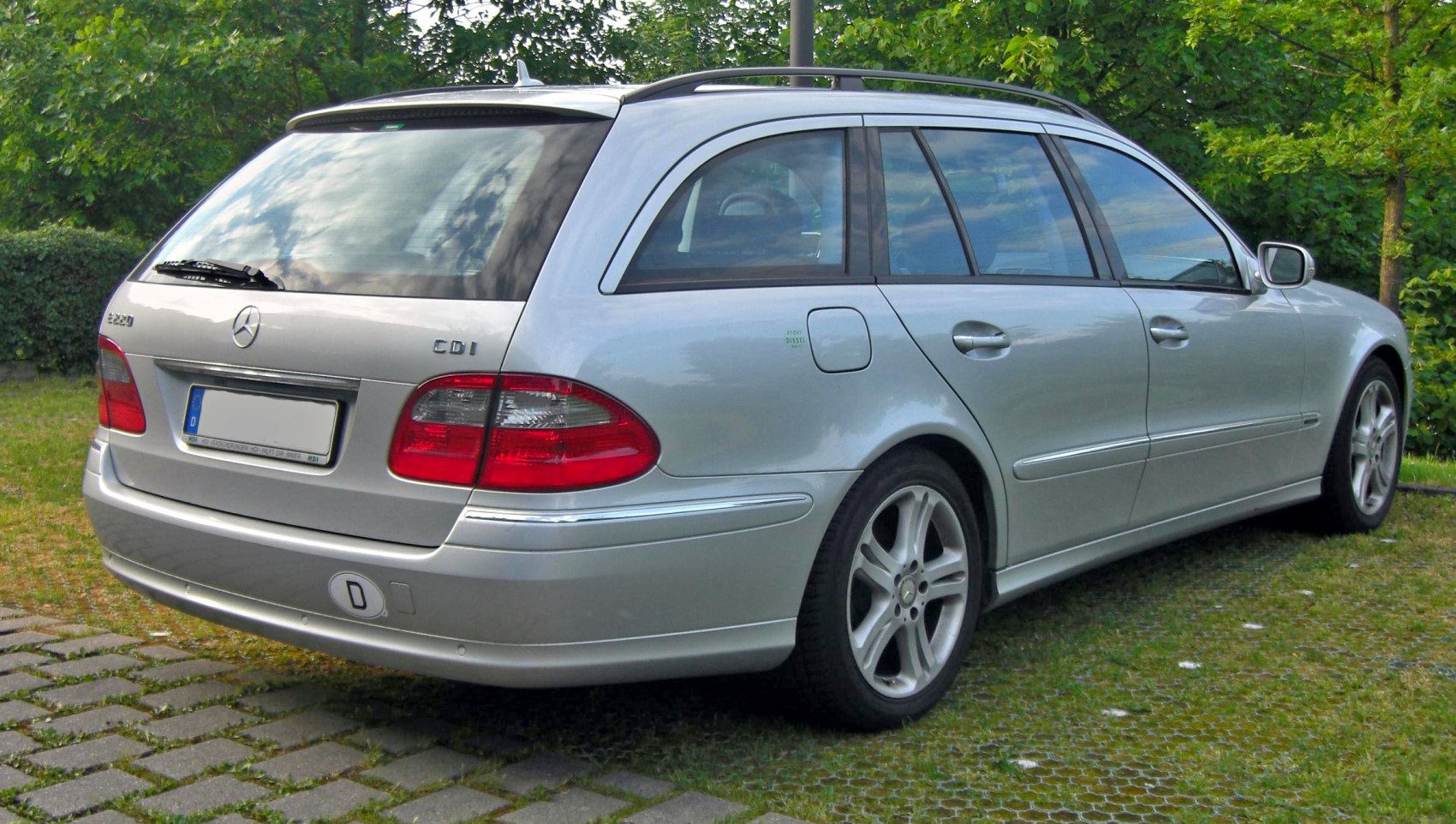 Rear side profile of silver station wagon with distinctive tail lights and roof rails