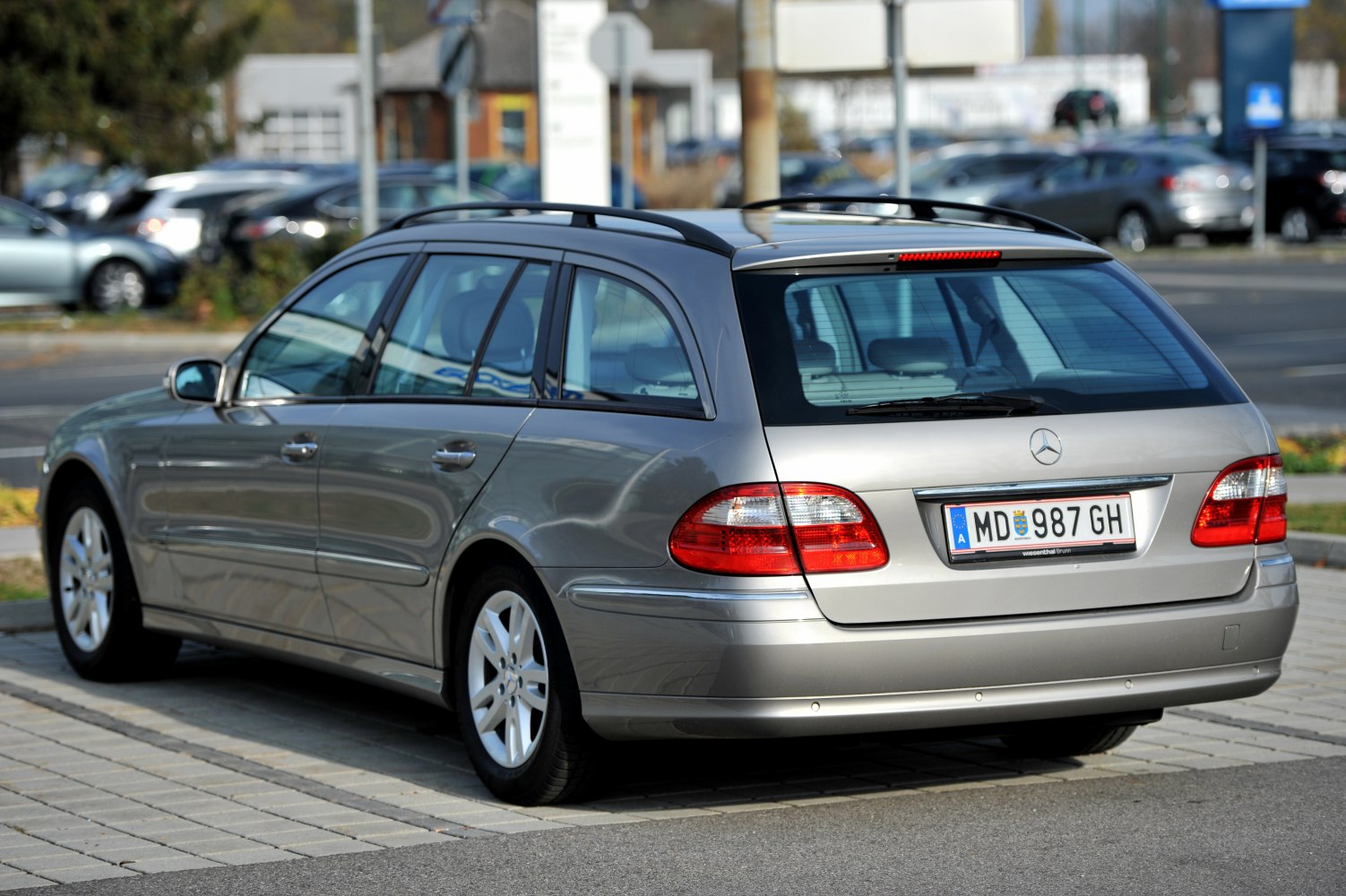 Rear side view of a station wagon with elongated body and roof rails