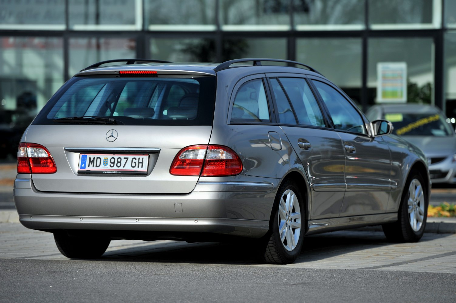 Rear view of a silver station wagon with roof rails and taillights