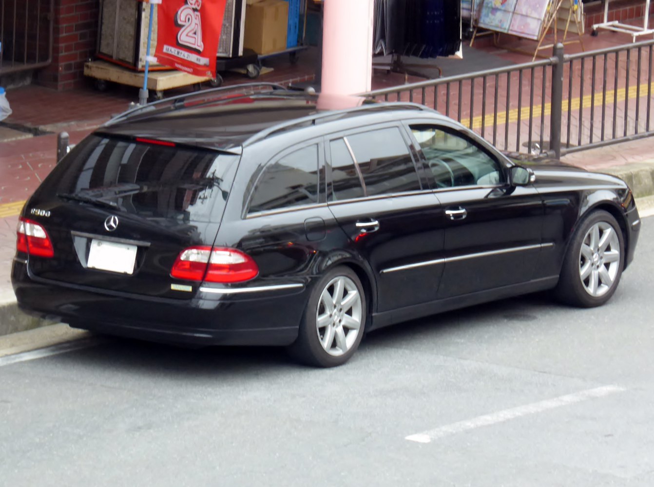Rear side view of black station wagon with roof spoiler and alloy wheels
