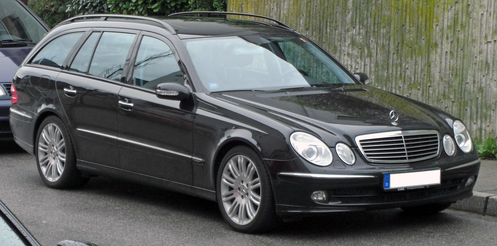 Side profile of a black station wagon with alloy wheels.