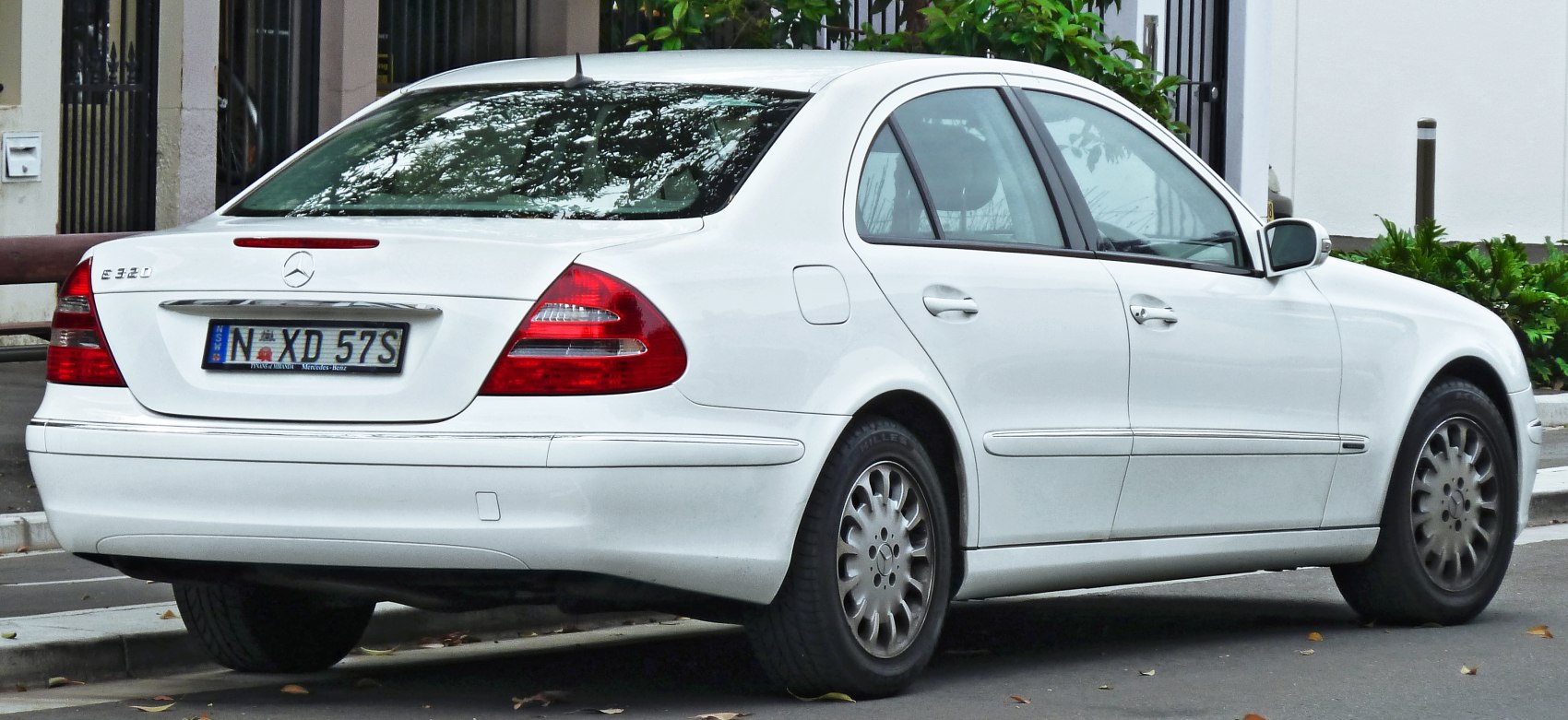 White luxury sedan rear side with classic body lines and taillights
