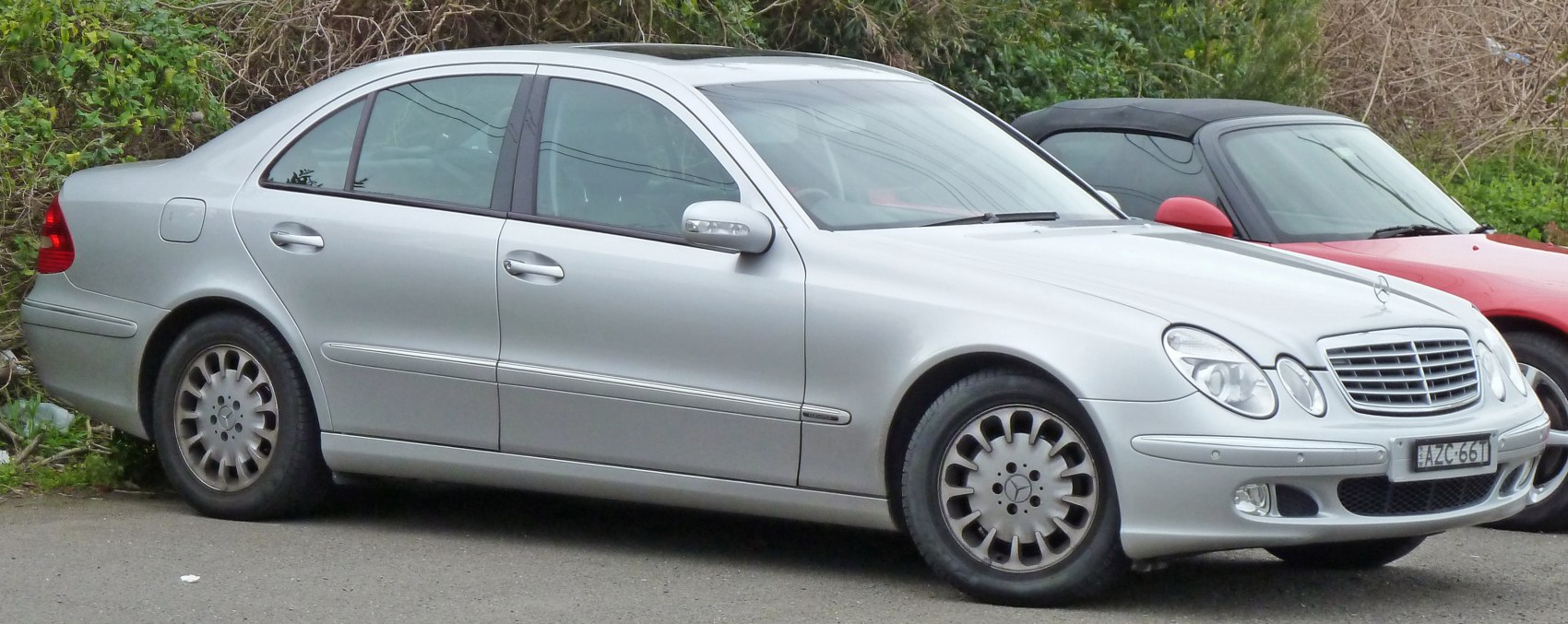 Silver sedan side profile with alloy wheels and round headlights