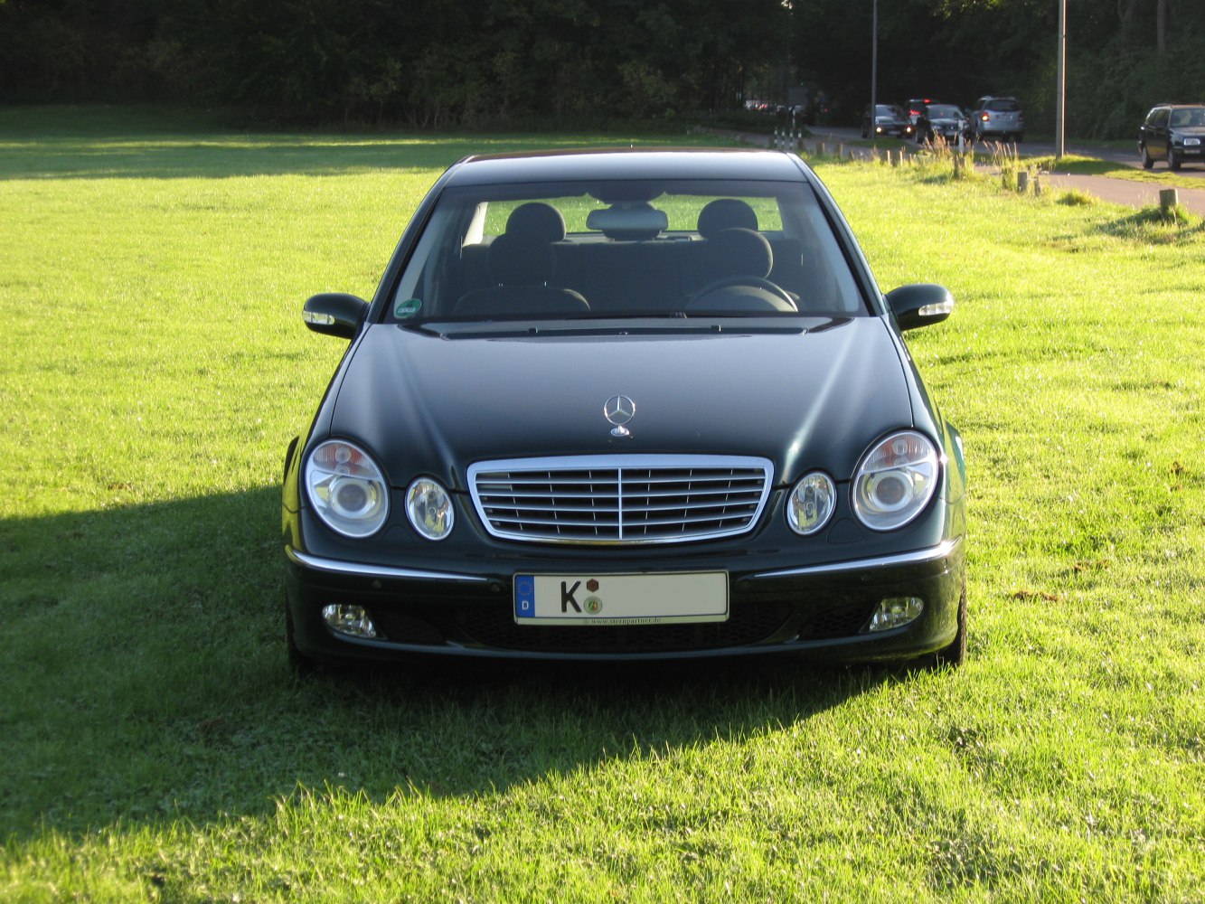 Front view of a luxury sedan with dual round headlights and chrome grille.