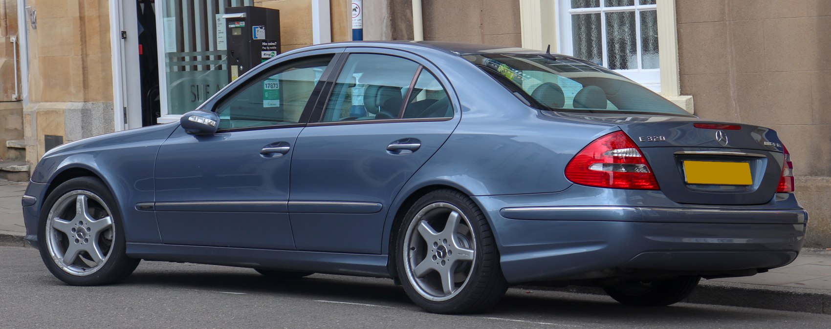 Rear-side sedan view with alloy wheels and distinctive taillights