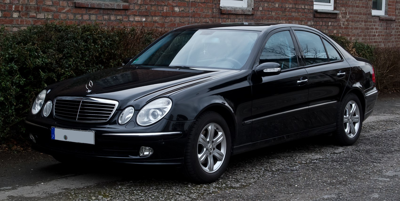 Luxury sedan with dual oval headlights and chrome grille in black
