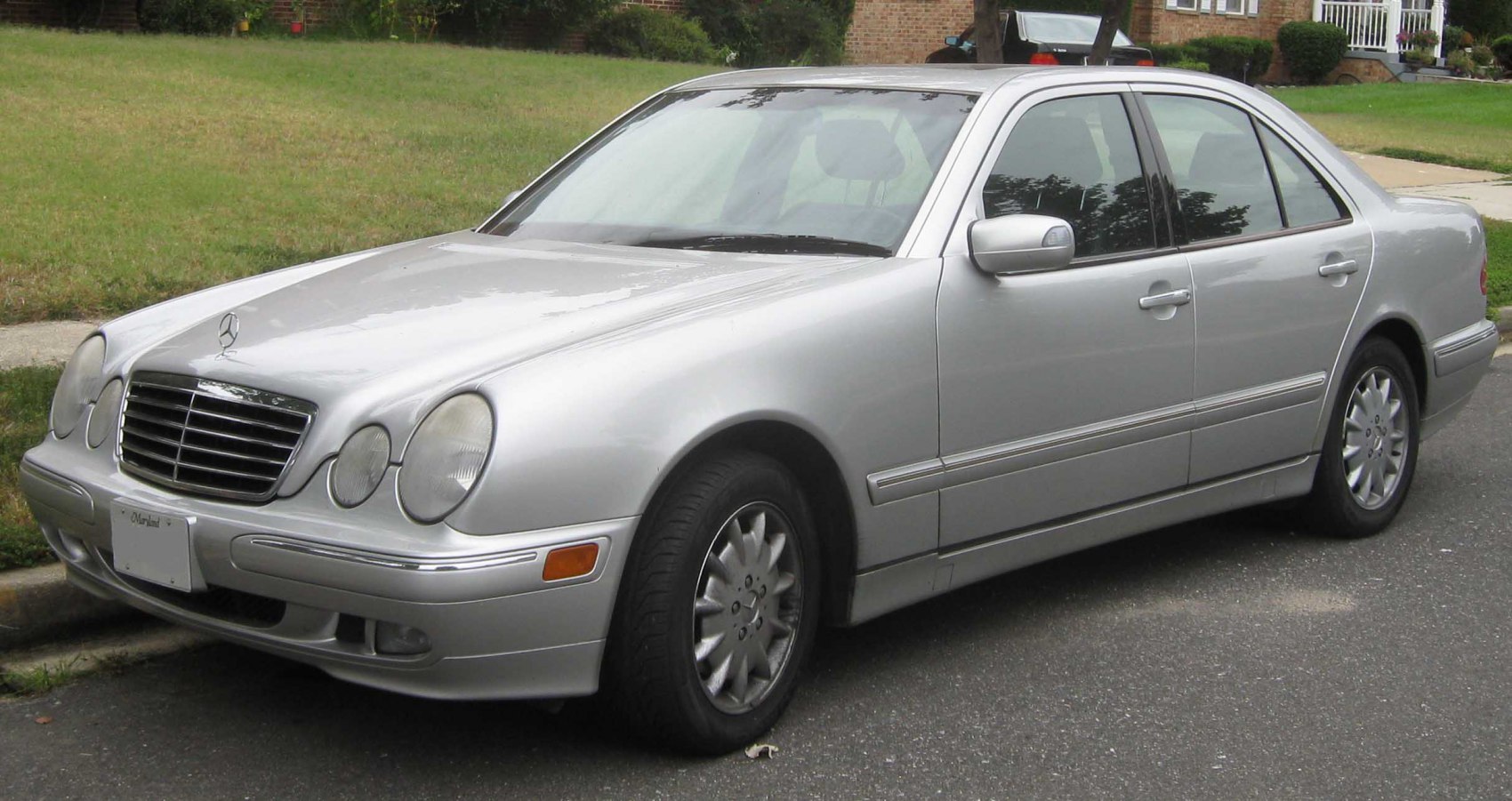 Silver sedan with dual rounded headlights and chrome grille.