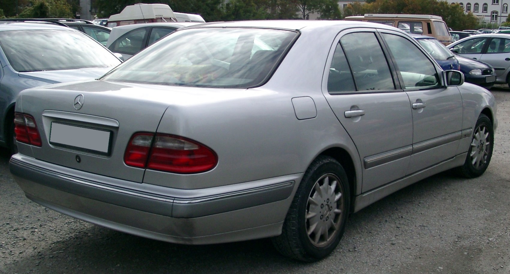 Rear and side view of silver sedan with red taillights and multi-spoke alloy wheels