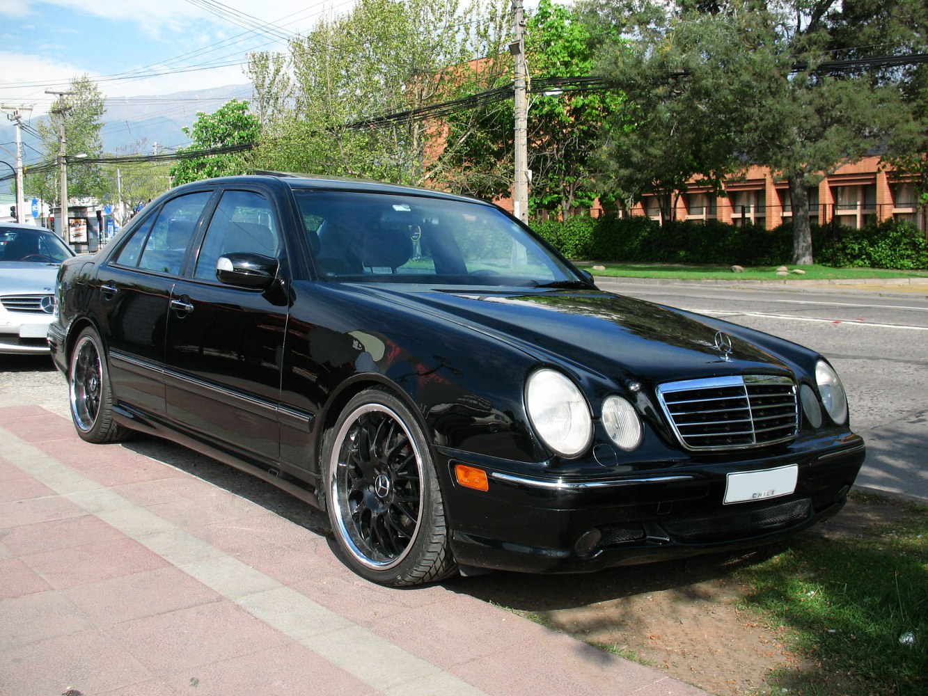 Black sedan with round headlights and custom black alloy wheels.