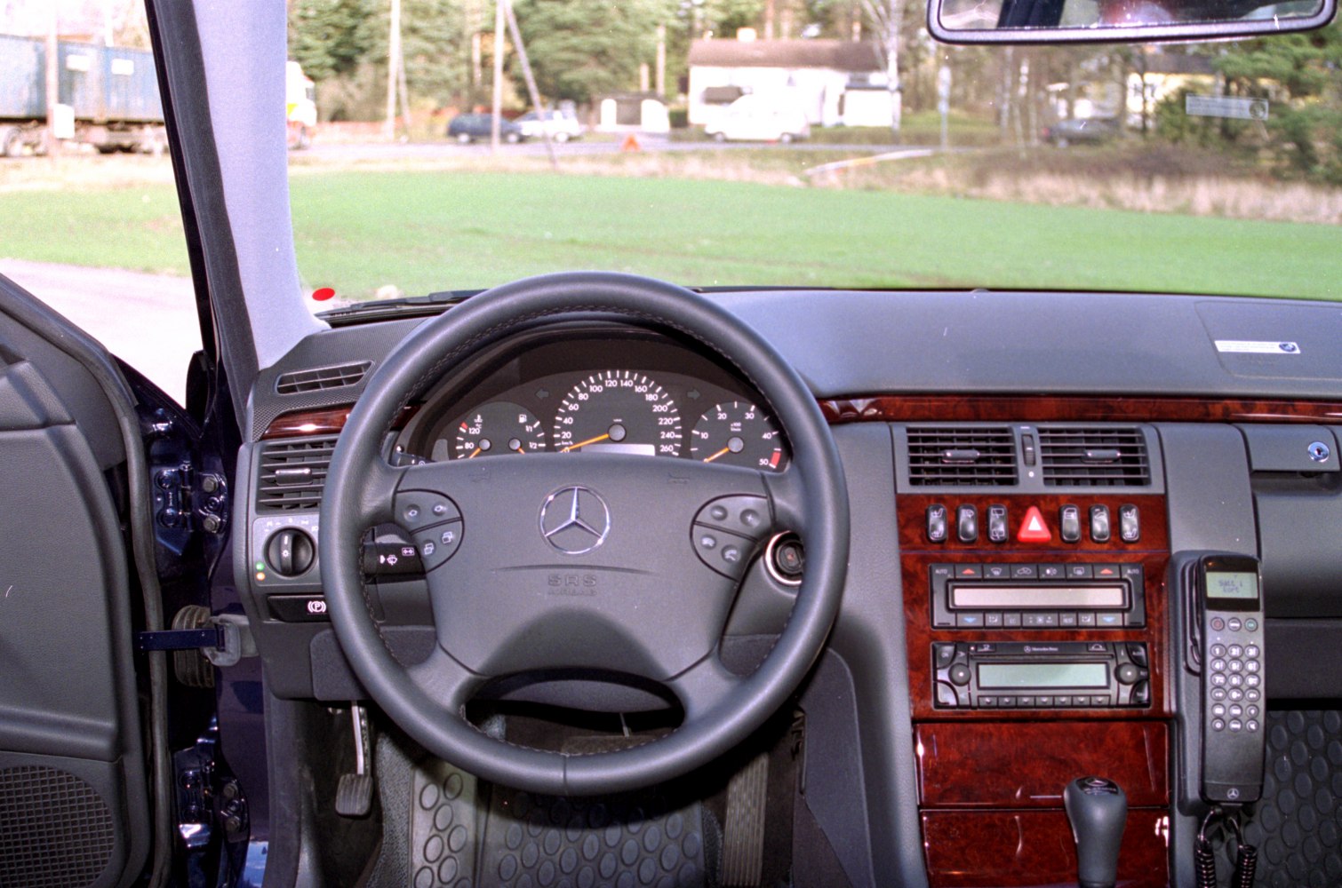 Steering wheel and dashboard with wood trim and integrated phone console