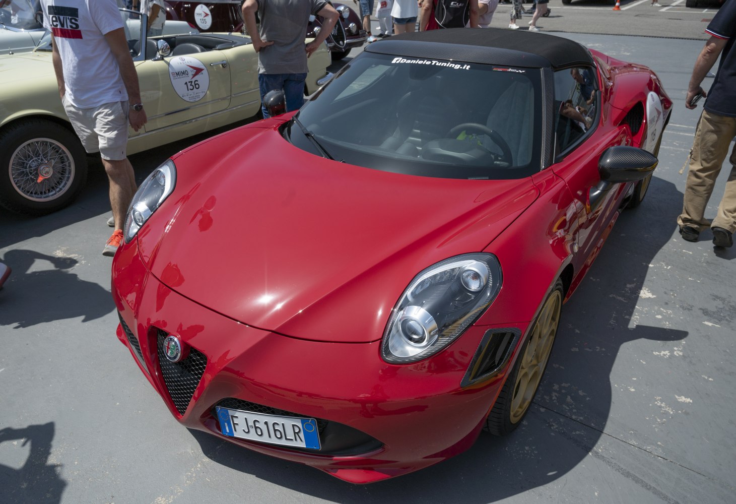 Front angled view of a red sports car with distinctive headlights and sleek hood design